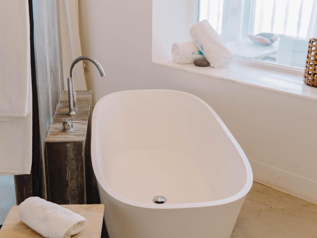 a white toilet in a bathroom with a window at Villa Singular in San José