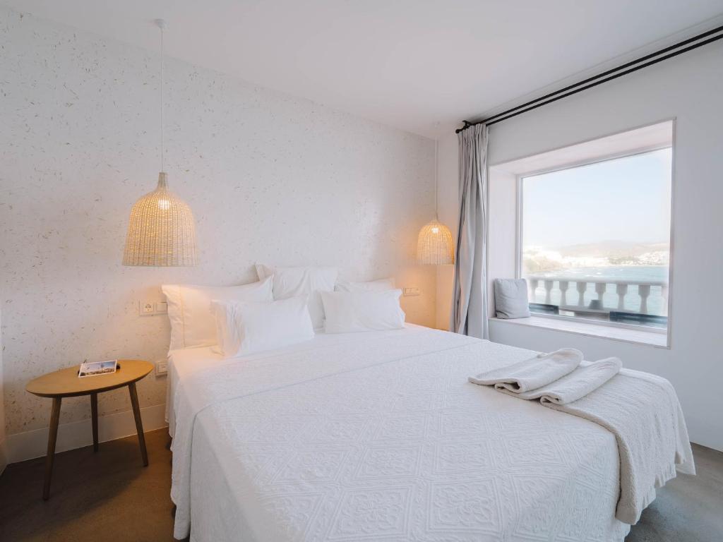 a white bedroom with a large bed and a window at Villa Singular in San José