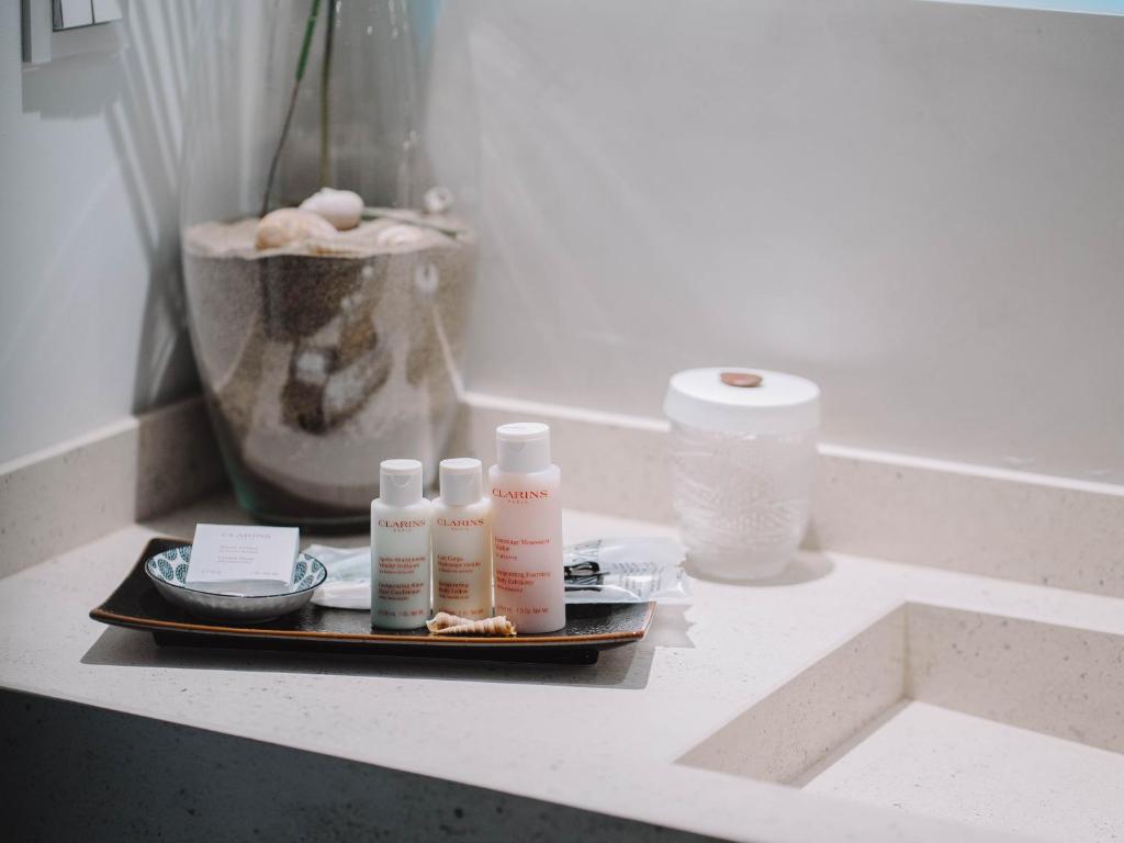 a tray with four bottles of cosmetics on a counter at Villa Singular in San José