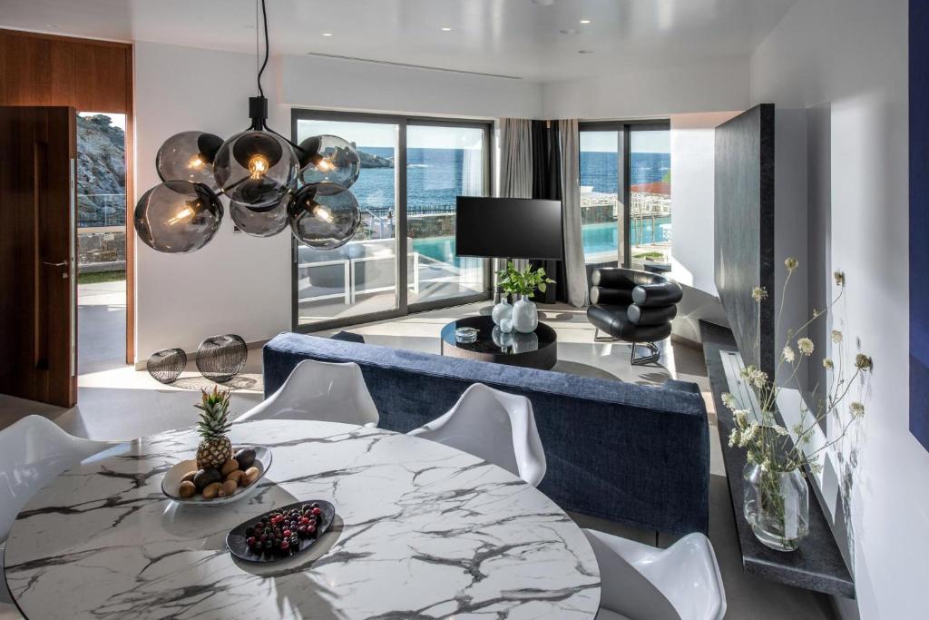 salon ze stołem i niebieską kanapą w obiekcie Made By The Sea Villas 8 BDRM w mieście Ligaria