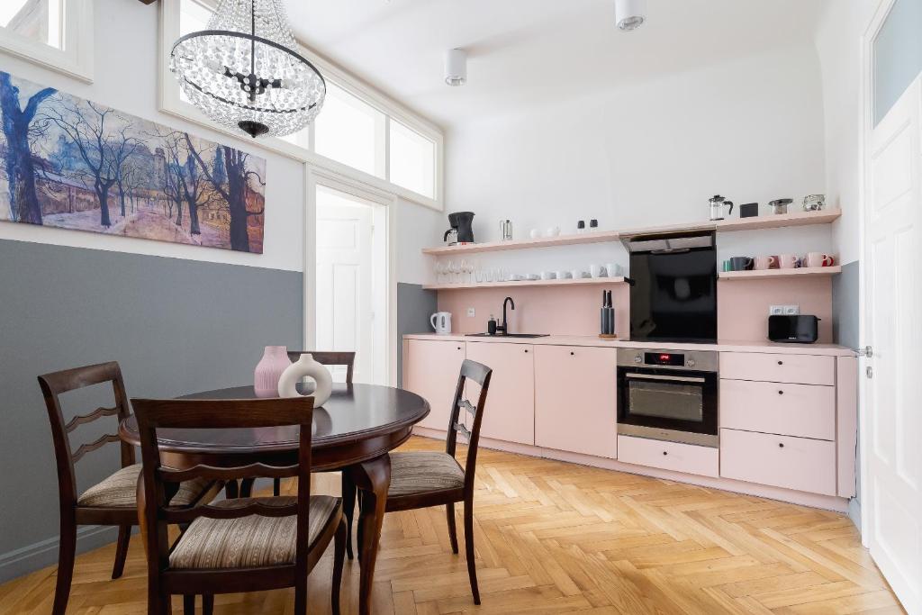 a dining room with a table and chairs and a kitchen at 2 bedroom apartment Św Jana - Main Square in Kraków