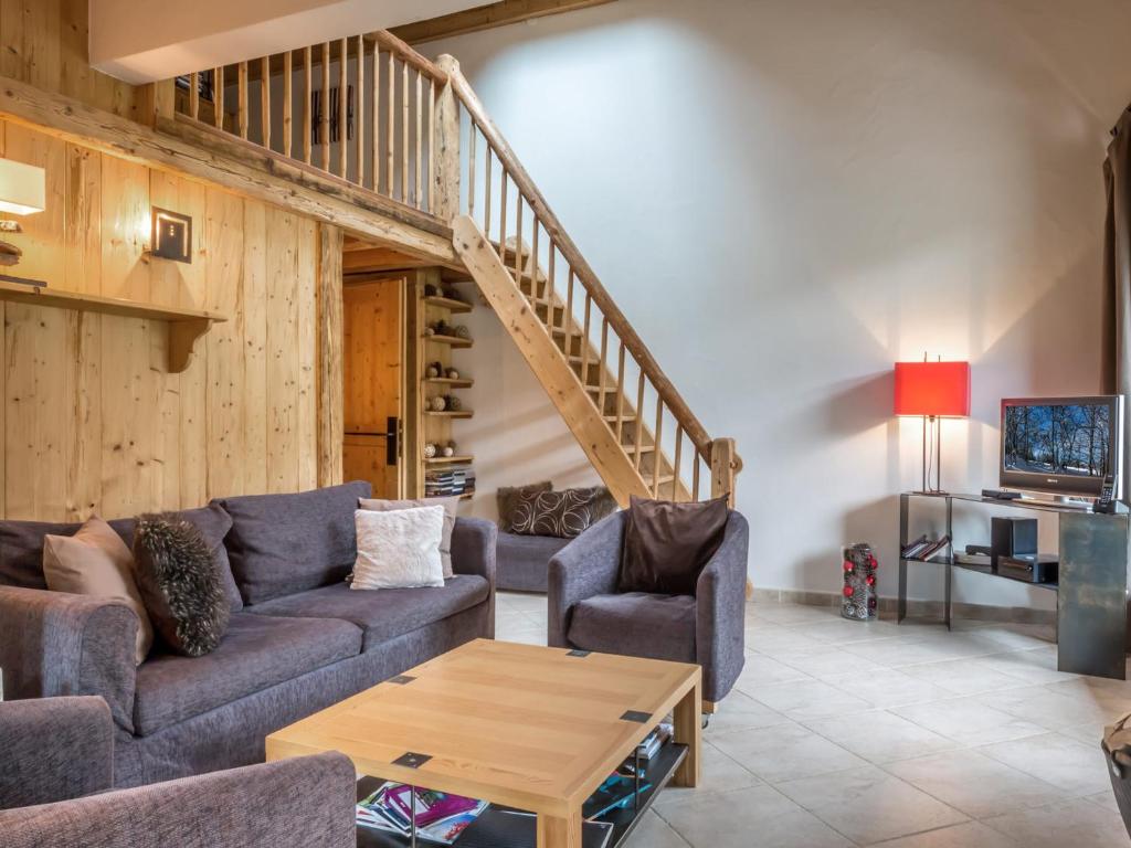 un salon avec un canapé et un escalier dans l'établissement Chalet moderne avec grands espaces, garage et WIFI - FR-1-304-131, à La Clusaz