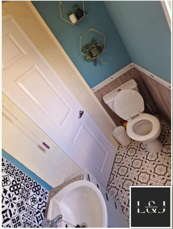 un baño con inodoro y lavabo en L&J Caravan Skegness, en Chapel St. Leonards