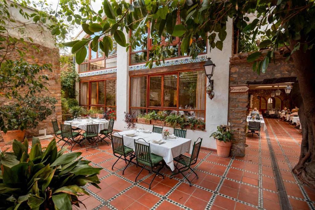 a patio with tables and chairs in a restaurant at Hotel Nou Rom&agrave; in Denia