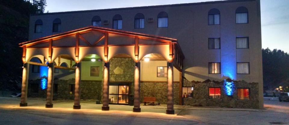 a large building with a lit up facade at night at Blackstone Lodge and Suites in Lead