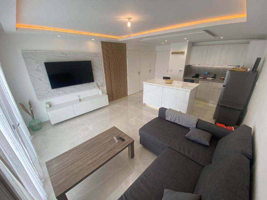 un salon avec un canapé et une cuisine dans l'établissement Appartement Cosy avec Piscine, à Ollioules