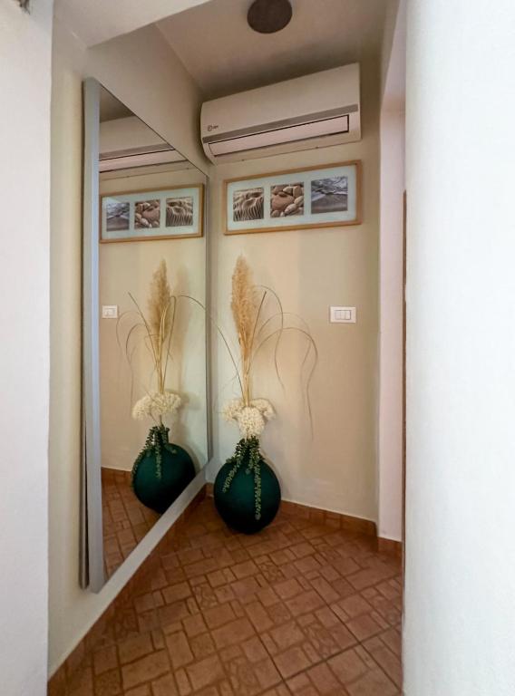 a hallway with two green vases with flowers in them at Apartmani Barica in Novigrad Istria