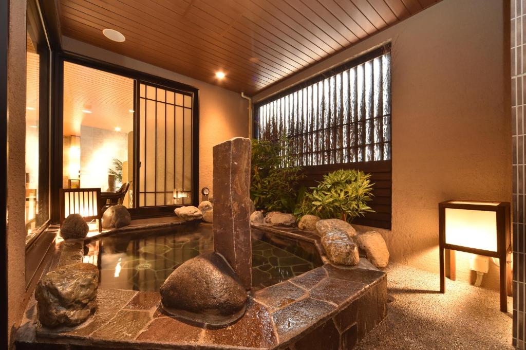 eine Lobby mit einem Pool mit Felsen und einem Brunnen in der Unterkunft Dormy Inn Higashi Muroran in Muroran