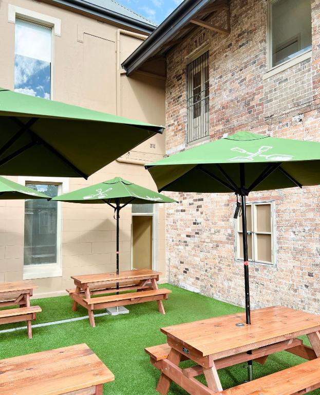 シドニーにあるTempe Hotel Sydneyの建物前の傘付きピクニックテーブル