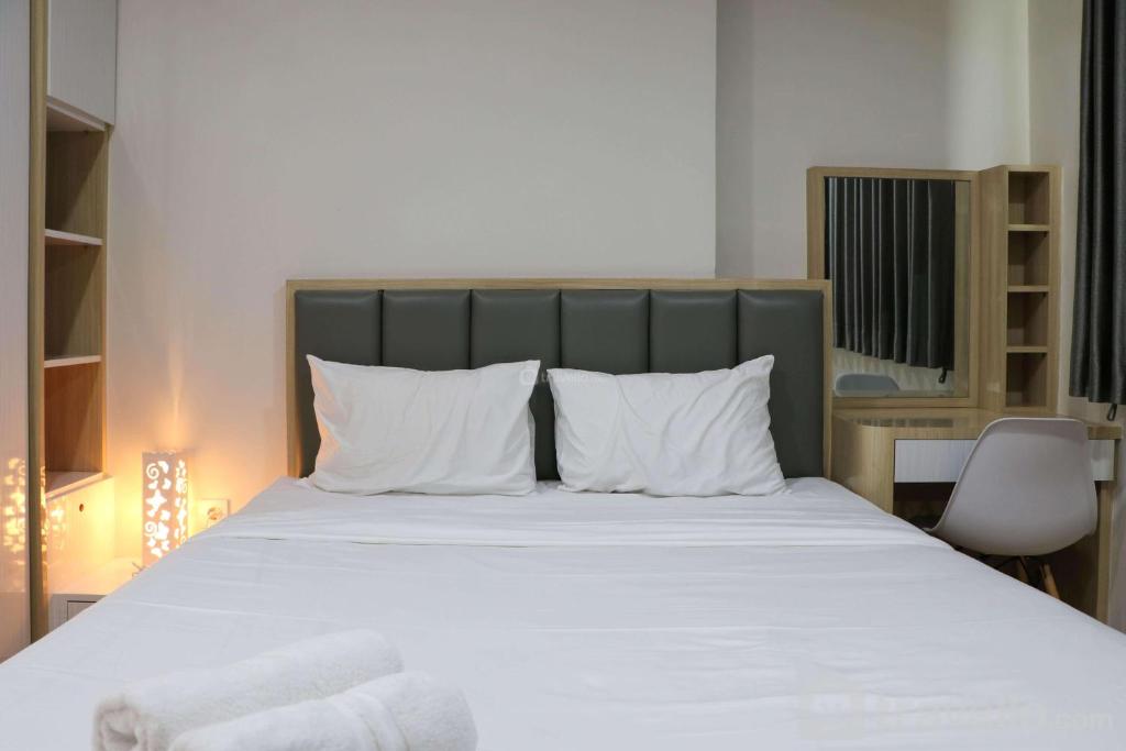 ジャカルタにあるElegant and Comfy 3BR Daan Mogot City Apartment By Travelioの白い枕が付いた大きなベッドのある寝室
