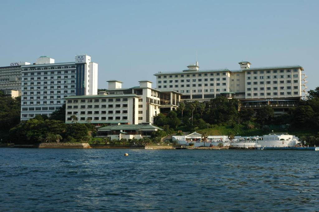 una gran masa de agua con edificios en el fondo en Toba Seaside Hotel en Toba