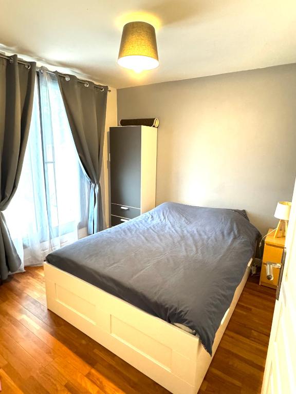 - une chambre avec un lit et un réfrigérateur noir dans l'établissement Chambres privées proche de Versailles, à Fontenay-le-Fleury