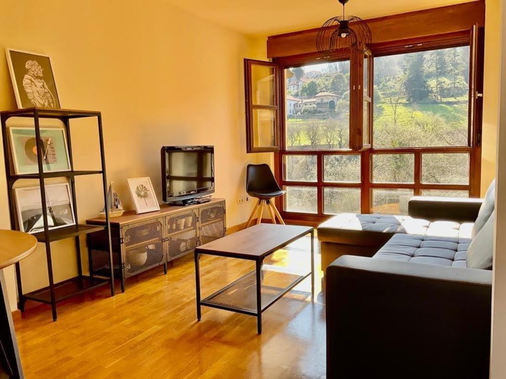 Una sala de estar con un sofá y un televisor. en La Casina de Noah en Soto de Luiña 304A, en Cudillero