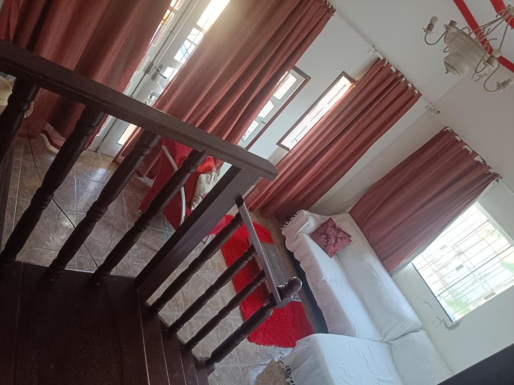 a living room with a white couch and red curtains at Casa primavera in São Pedro da Aldeia