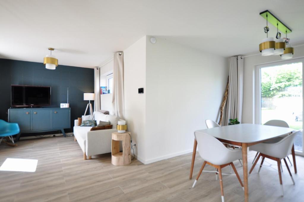 a living room with a table and a couch at Le sourire - Maison avec Jardin, Bureau & BBQ in Rochefort