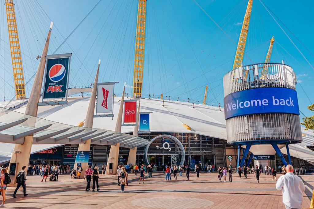 a crowd of people walking in front of a nintendo belt stadium at Greenwich-the 02 two in London