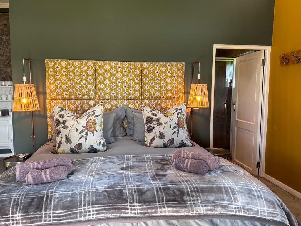 a bedroom with a large bed with two pillows at Tzamenkomst River Lodge in Colesberg