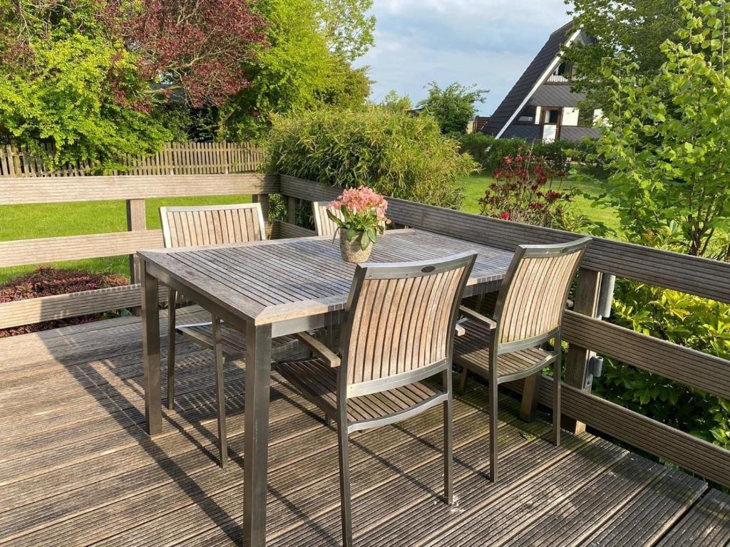 a wooden table and chairs on a wooden deck at Ferienhaus in Fedderwardersiel mit Terrasse in Butjadingen