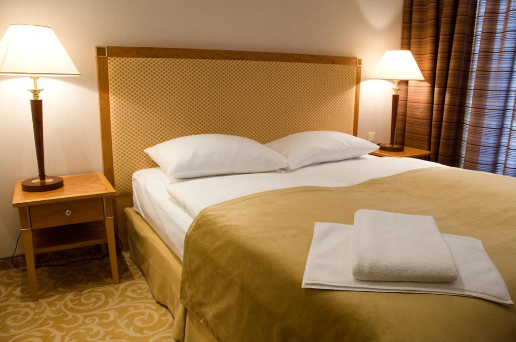 a hotel room with a bed with two towels on it at Amber SPA Boutique Hotel in Jūrmala
