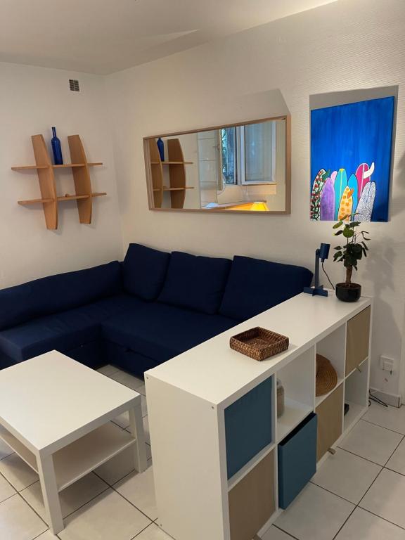 un salon avec un canapé bleu et une table dans l'établissement Appartement BIARRITZ, à Biarritz