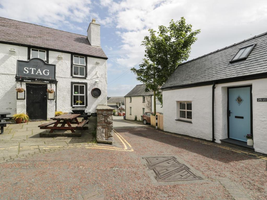 a building with a picnic table in front of it at Llofft Penwaig The Herring Loft in Cemaes Bay