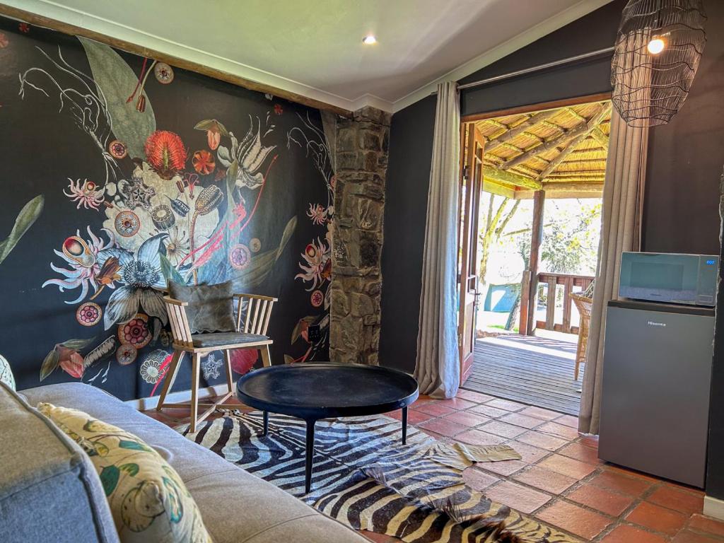 a living room with a mural of flowers on the wall at Tzamenkomst River Lodge in Colesberg