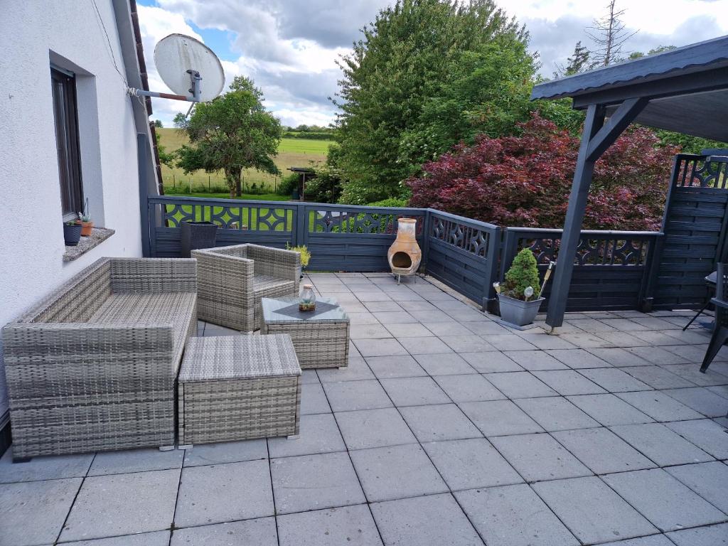 a patio with wicker furniture and a blue fence at Ferienwohnung Parkblick Medebach in Medebach