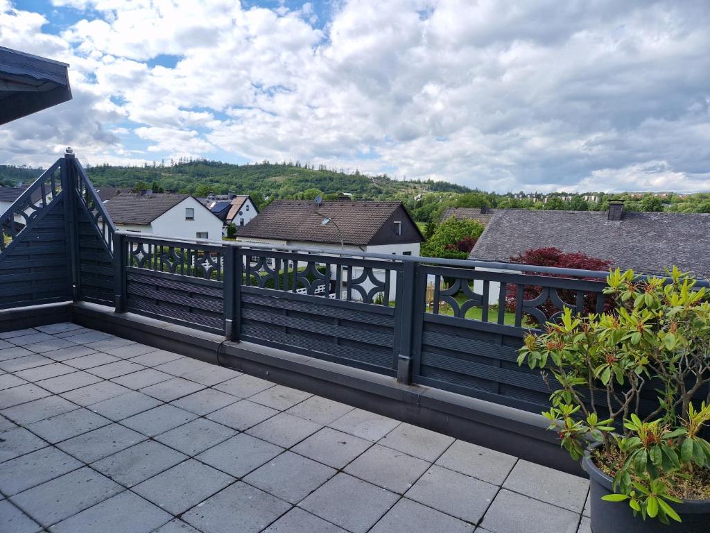 a balcony with a wooden fence and some houses at Ferienwohnung Parkblick Medebach in Medebach