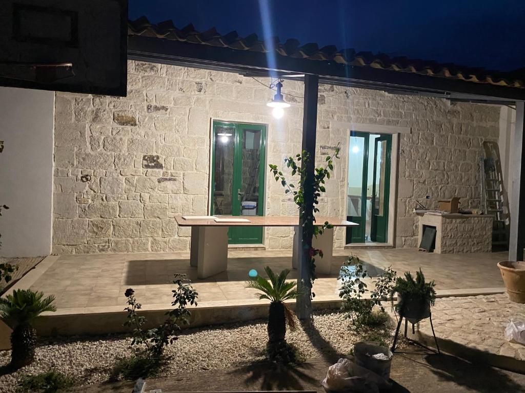 een patio met planten en een tafel in een gebouw bij Casa San Vito in Modica