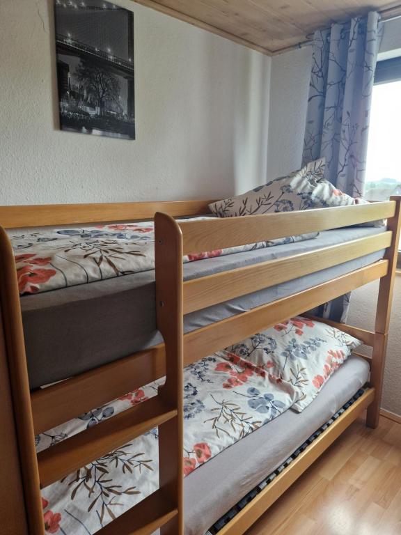 a bedroom with two bunk beds and a window at Ferienwohnung Parkblick Medebach in Medebach