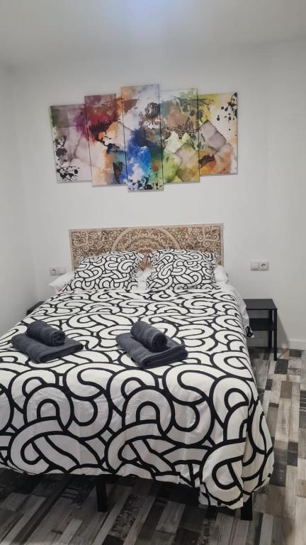 a bedroom with a black and white bed with two pillows at Apartamento Soria Calaverón in Soria