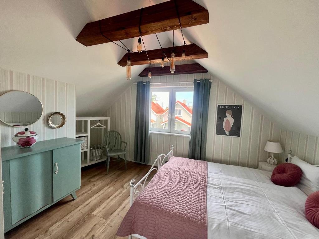 a bedroom with a large bed and a window at Goose Home and Garden in Łeba
