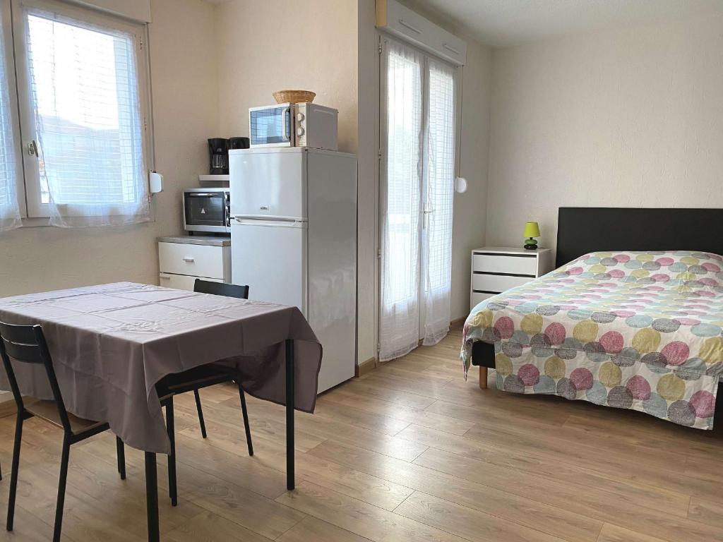 - une chambre avec un lit, une table et un réfrigérateur dans l'établissement Studio rénové avec balcon, proche commerces, wifi et cellier privatif - Balaruc-les-Bains. - FR-1-553-13, à Balaruc-les-Bains