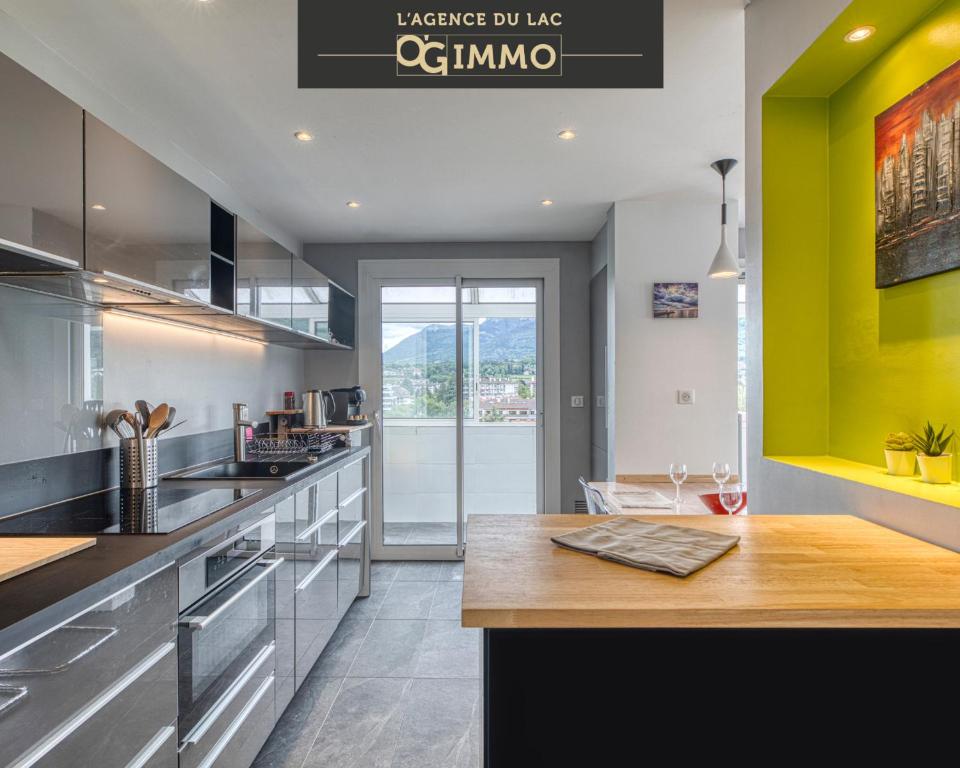 une cuisine avec un comptoir et un mur jaune dans l'établissement Le Central Park, à Annecy