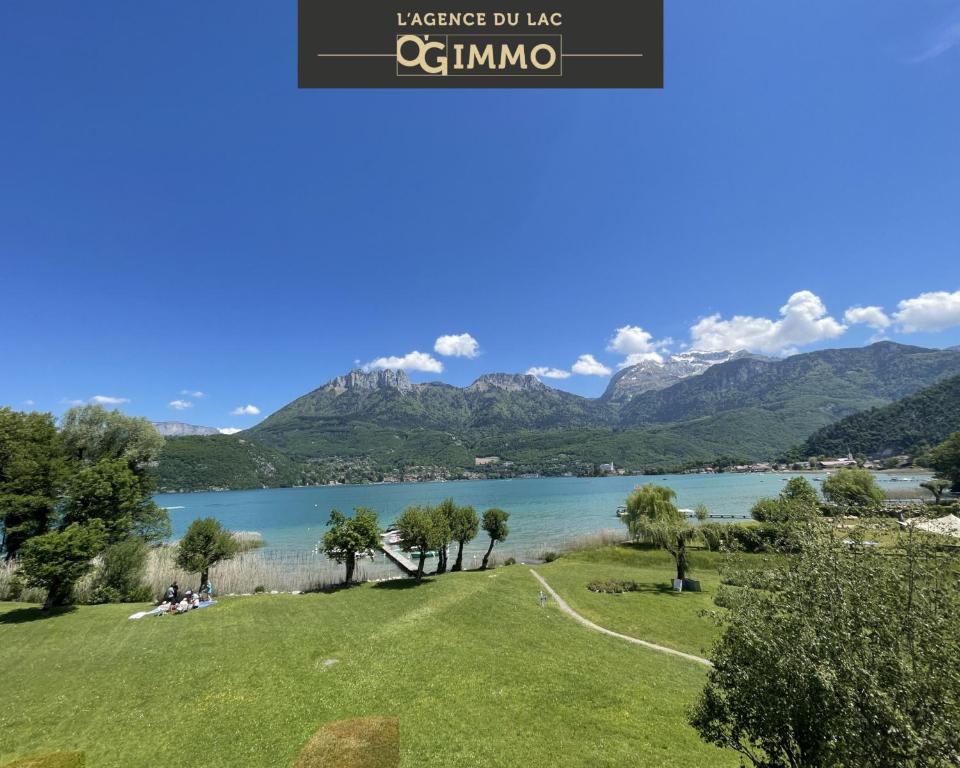 Una vista de un lago con montañas al fondo. en Lac paradisiaque, en Duingt