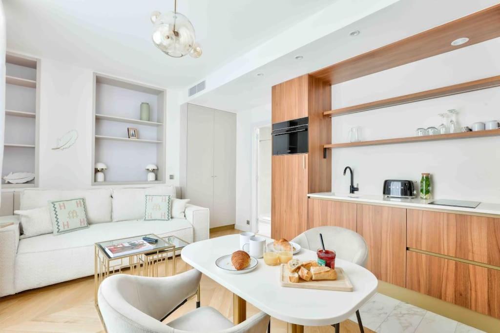 un salon avec une table et des chaises blanches dans l'établissement Romantic Getaway - Le Marais - with AC, à Paris