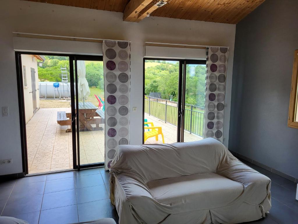 a living room with a white couch and a patio at Villa avec magnifique point de vue 160 m2 in Blars