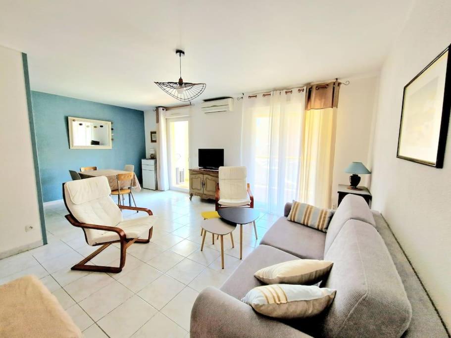 un salon avec un canapé et des chaises dans l'établissement Mar Vivo- plage à pieds, à La Seyne-sur-Mer