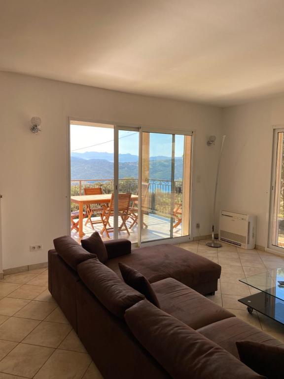 un salon avec un canapé et une table avec vue dans l'établissement Maison près de Coti-Chiavari, à Coti-Chiavari