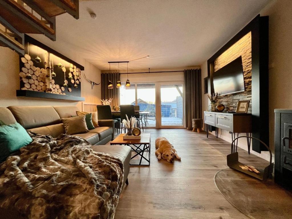 a living room with a couch and a dog in it at Luxuriöses, renoviertes Haus mit Garten, Gratis WLAN, Hund willkommen in Zandt