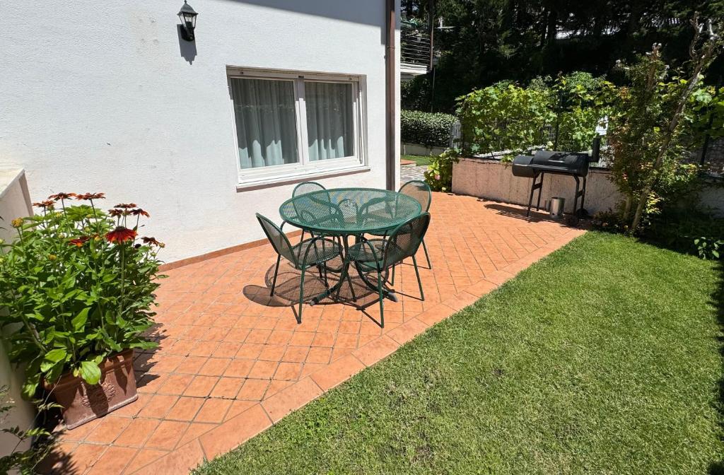 einen Glastisch und Stühle auf einer Backsteinterrasse in der Unterkunft Casa Sole in Costermano sul Garda