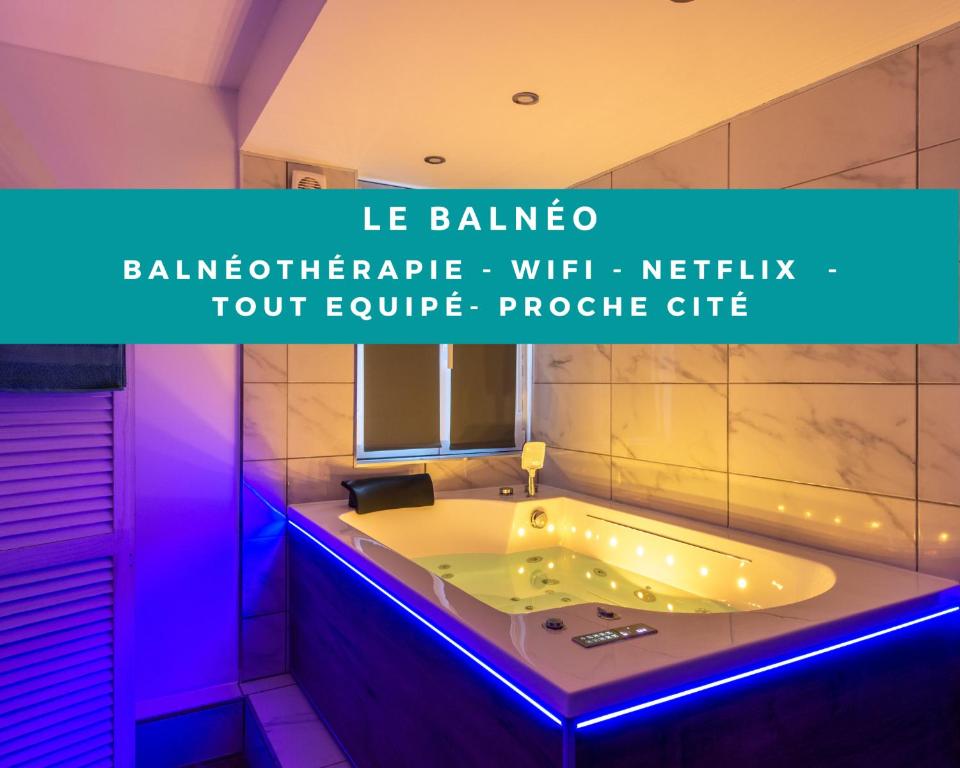 La salle de bains est pourvue d'une baignoire avec des lumières violettes. dans l'établissement El Balneo - wifi - central - tout à pied - netflix - parking, à Carcassonne