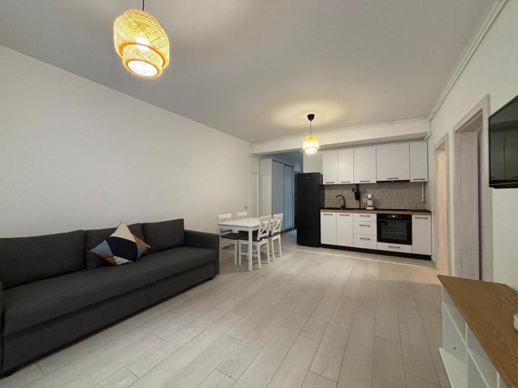 a living room with a couch and a table at Velvet Breeze Apartment in Năvodari