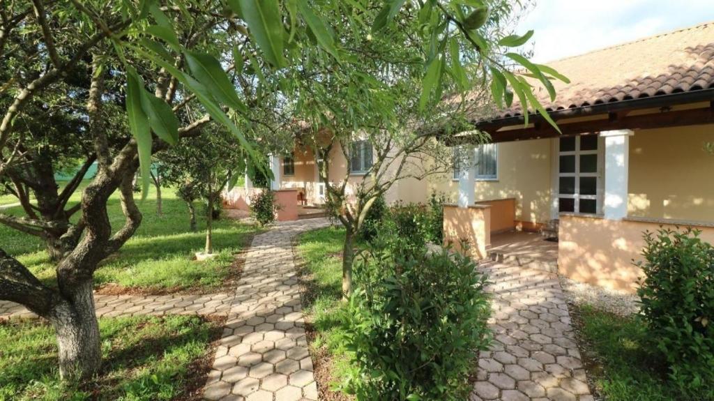 a house with a walkway in front of a yard at Bungalow Melisa mit Pool in Porec in Poreč