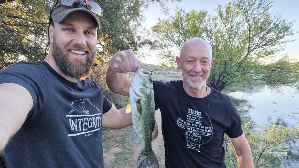 two men holding a fish in their hand at Tzamenkomst River Lodge in Colesberg