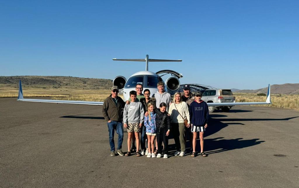 a group of people standing in front of an airplane at Tzamenkomst River Lodge in Colesberg