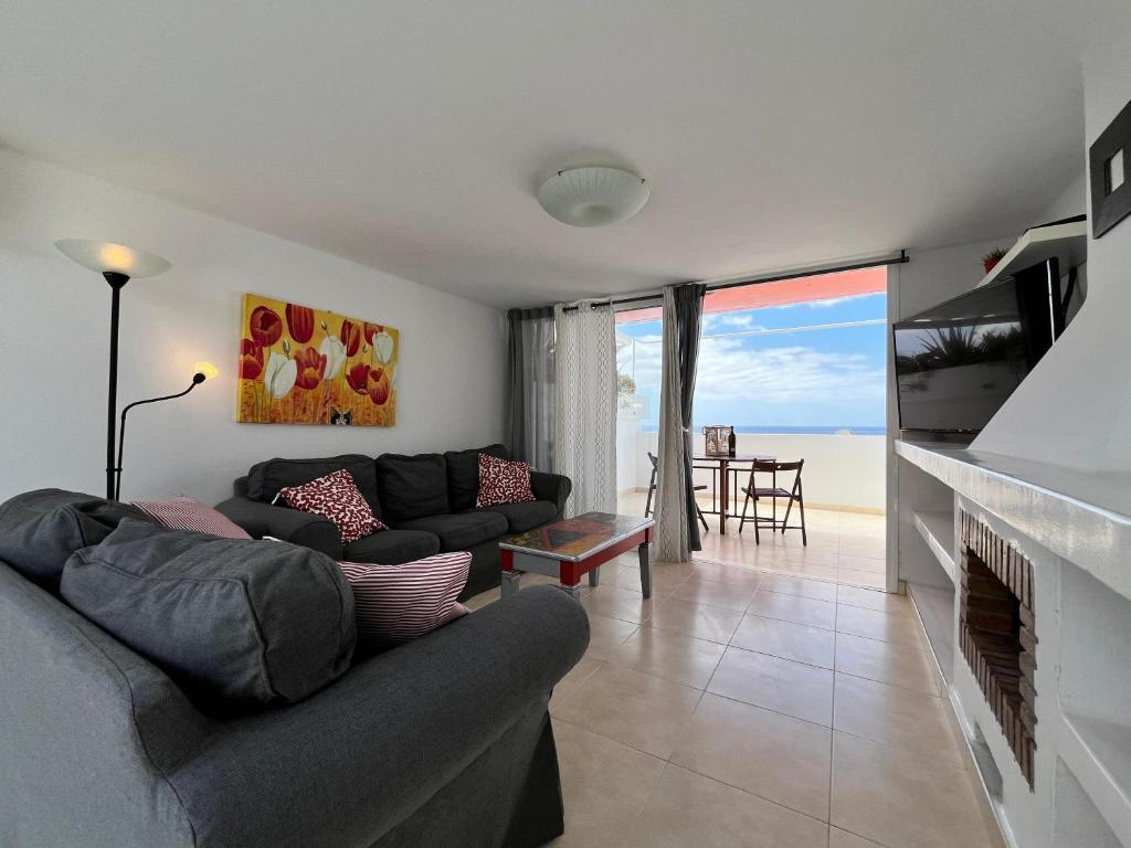 a living room with a couch and a fireplace at Casa Oda Seaview in Puerto del Carmen