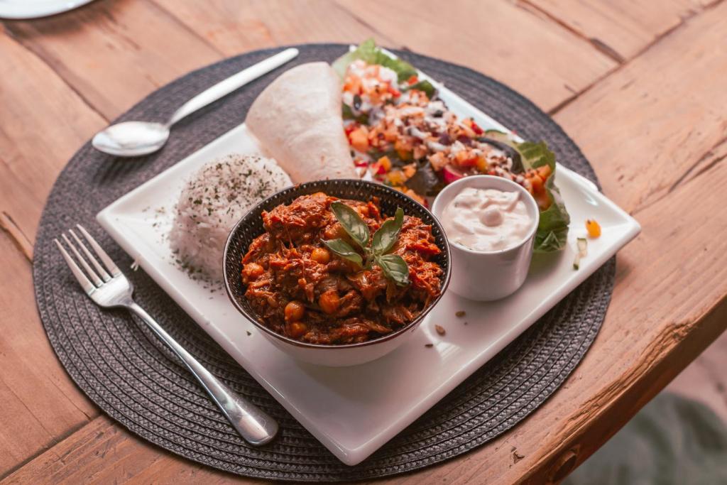 a plate of food with a bowl of food on a table at Tzamenkomst River Lodge in Colesberg