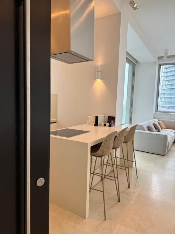a kitchen and living room with a counter and chairs at Olympic Residence Deluxe Apartments in Limassol