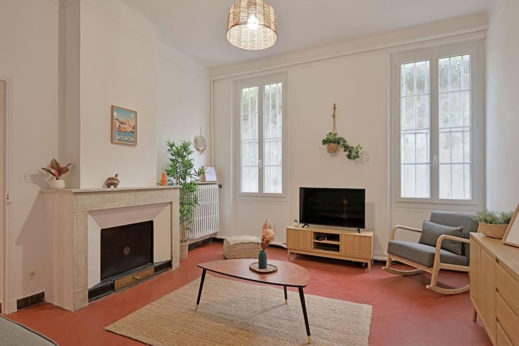 un salon avec une cheminée et une télévision dans l'établissement Le Banastier - AC CLIM - Wi-Fi - Palais des Papes à 200m, à Avignon